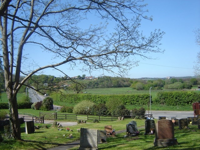 Graveyard with a view, St Martin's church As well as the graveyard, this picture shows the junction of the side road to the church with the road from Llanmartin to Underwood, and the road as it approaches its crossing of the M4. In the far distance on the horizon to the right you can just make out the famous Celtic Manor Hotel in Newport.