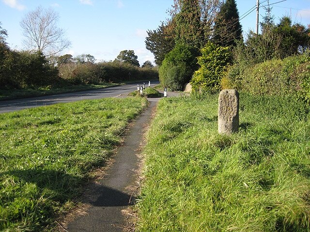 The White Stone, Withington, Herefordshire, seen from the east. A stone shaft beside the A4103 main road, inscribed with distances to Hereford, Ledbury, Leominster and Worcester.