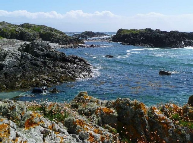 Coastal colour below Ben Hynish Thrift and lichen on the rocks in the foreground contrast with the deep blue of the sea on a typically breezy Tiree day. Looking south, the next land is the Irish coast.