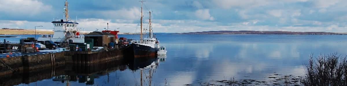 Photo "Longhope Pier The vessels that brought the partygoers to Longhope yesterday." by Ian Balcombe (Creative Commons Attribution-Share Alike 2.0) / Cropped from original