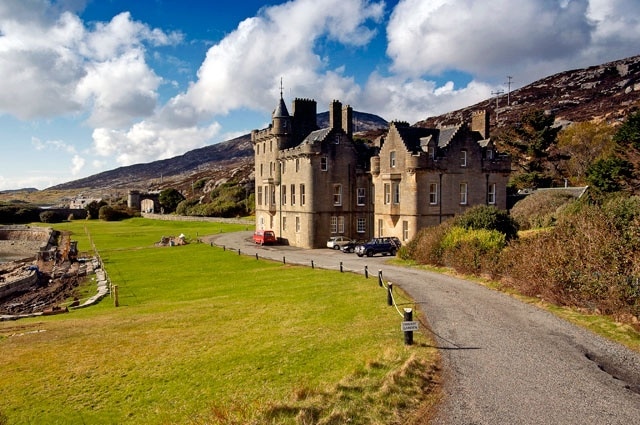 Amhuinsuidhe Castle near to Amhainn Suidhe, Na h-Eileanan an Iar, Great Britain. The B887 road runs right through the grounds in front of the house and out through the gateway in the distance. The house was built in 1865 for the 7th Earl of Dunmore, the then owner of the Isle of Harris.
