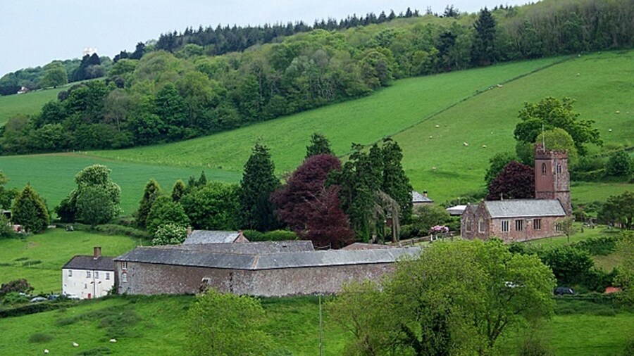 Photo "View of Dunchideock Dunchideock is Celtic and means 'the wooded fort or camp,' possibly referring to the earthwork of Cotley Castle which is nearby. The church is a late 14th century building, restored in 1875-7 and 1889, when the chancel was rebuilt." by Trish Steel (Creative Commons Attribution-Share Alike 2.0) / Cropped from original