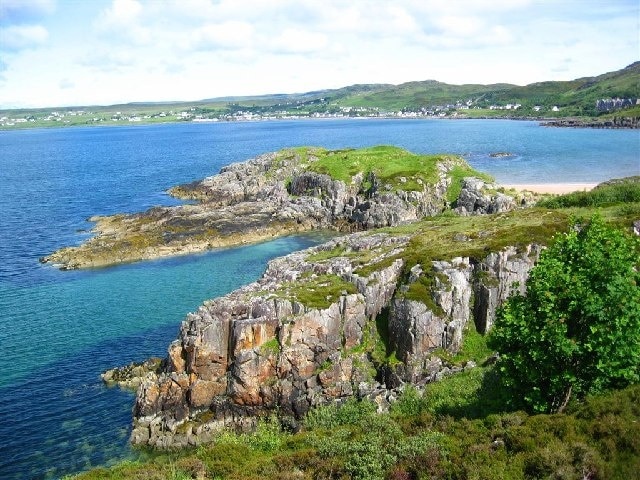 Rocky Promontory by Gairloch Beach. This photo was taken at 9:55am on 18th June, 2004, from the footpath from the harbour. The further headland was used as an ancient fort. Across the loch is Strath.