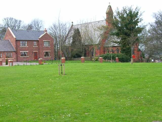 View northwest across part of the village green at Cornforth, County Durham, with Holy Trinity parish church on the right