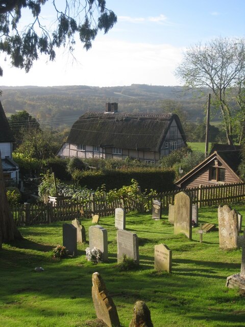 Thatched Cottage on Bell Alley Road Viewed through the graveyard of St Bartholomew's Church.