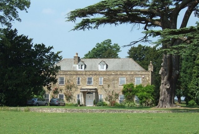 West Park Farm - The Farmhouse. A close-up of the farmhouse with a massive Cedar to the right.