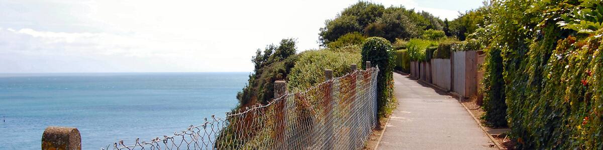 Photo "Part of the coastal footpath that goes between Sandown and Shanklin. A drop of a couple of hundred feet here. Not for those with vertigo." by Ronald Saunders (Creative Commons Attribution-Share Alike 2.0) / Cropped from original