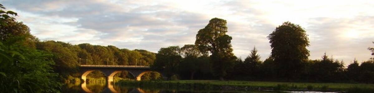 Photo "Weir at Woodside A weir on the river Don in the Woodside area of Aberdeen caught in summer evening sunlight. This is a lovely stretch of river to walk along where you feel much further from the city than you are." by Jenny Embleton (Creative Commons Attribution-Share Alike 2.0) / Cropped from original