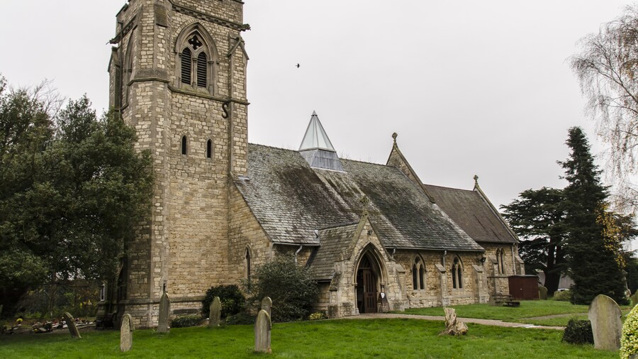 Photo "There has been a church on the site since the 13th century. By 1854 the church was in a dilapidated condition and was rebuilt in 1855 by Hussey, using much of the old materials. There was a nave with clerestory, north and south aisles, and also a spire on the tower roof. The lower stages of the tower still contain some mediaeval masonry. In 1916 there was a severe fire which left only the walls standing. Due to limited funds, only the chancel was given a permanent roof, the nave had a temporary roof which lasted nearly 80 years! The spire was never rebuilt, and the aisle arcades replaced with brick and concrete ones. The church was re-ordered in 1992 when the nave and aisle roofs, internal columns and pews were removed, and a new roof which spans the whole width of the church containing a glass lantern skylight. Services are now held in the nave part of the church, with the chancel being used for the creche and for more intimate services. There is a fine east window by Edward Payne. The church now has a Kitchen, toilet and Wi-fi." by Jules & Jenny (Creative Commons Attribution 2.0) / Cropped from original