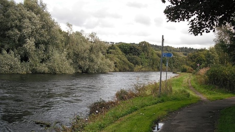 Photo "River Leven The cycle path (NCN 7)leaves the river ever so briefly to rejoin it a few metres on by path and about 1km further on by river. The river forms a big loop here and the path just cuts across the neck." by Richard Webb (Creative Commons Attribution-Share Alike 2.0) / Cropped from original