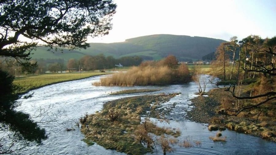 Photo "The Leithen Water meets the Tweed Just south of Innerleithen. The Leithen Water is flowing in from the right. Both rivers are very high after two weeks of almost continuous rain." by Gordon Brown (Creative Commons Attribution-Share Alike 2.0) / Cropped from original