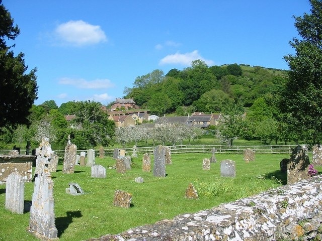 Churchyard, Chiselborough, Somerset. Looking across the churchyard of the Church of St. Peter and St. Paul. Beyond the fence is an orchard. On this day the village was filled with the heavy scent of many flowers in the cottage gardens.