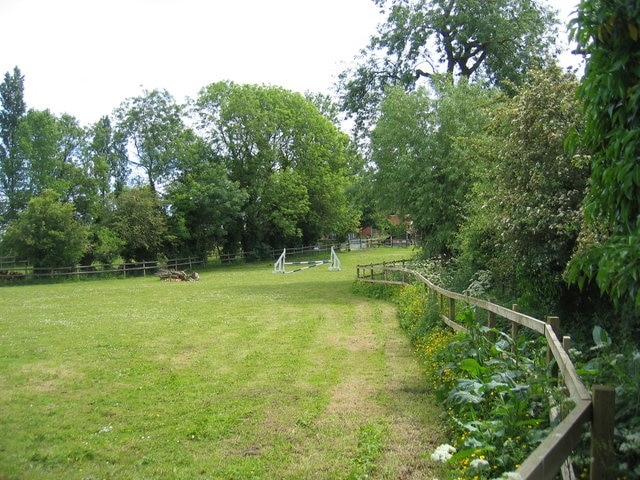 Footpath at Ettington. The footpath runs between the edge of the paddock on the left and a new housing development to the right of the hedge. At this time of year the undergrowth is trying to take over!