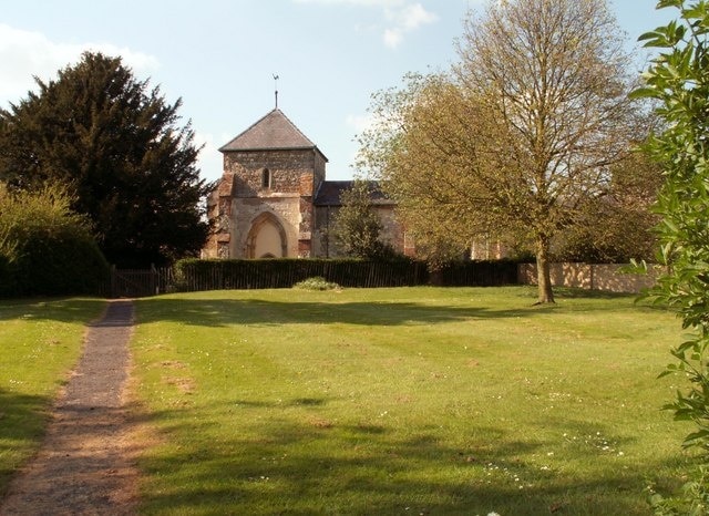 St. Guthlac: the parish church of Astwick The exterior of this church shows that it was once a cruciform church. The arch over the entrance was once the opening into the south transept. This is the view from the roadside gate.