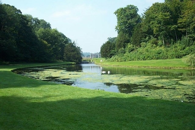 Fountains Abbey. The River Skell has been carefully controlled by a series of weirs to make ornamental ponds - this one reflecting the abbey in the background.