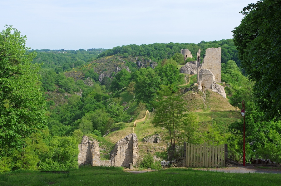 Crozant (Creuse). Ruines de la forteresse de Crozant (XIIIe, XVe). Aux portes de l'ancienne province de la Marche*, la forteresse est située sur un éperon granitique surplombant le confluent de la Creuse et de la Sédelle.
Le relief particulier du site, l'avait probablement fait choisir comme lieu de défense depuis le néolithique. Trois époques d'installation sont incontestables : le bronze moyen, le bronze final et le premier âge du fer (Sondages archéologiques effectués entre 1964 et 1974 par Benjamin Lasnier) Les premières fortifications peuvent peut être être attribuées aux Wisigoths* qui cherchaient à protéger leur frontière septentrionale des Goths. Le nom même de Crozant, forme dérivée de "Crozenc", serait d'origine franque (suffixe germanique "enc")*. Les premières traces écrites sur Crozant remontent au début du XIème siècle. D'après les chroniques de Geoffroy de Vigeois, Gérald (ou Géraud ou Gérard), comte de Crozant et vicomte de Bridiers, vend la Villa Sosterranea (La Souterraine dans la Creuse) à l'Abbaye Saint-Martial de Limoges. Par contre, le château n'est cité, dans les mêmes Chroniques, que vers le milieu du XIIe siècle (1140). (généalogie par Cedric de Crozant de Bridiers). La construction la plus ancienne serait la base du donjon carré qui pourrait remonter au XIIe siècle. En 1177, le comté de la Marche, dont Crozant fait partie, est cédé au duc-roi Henri II Plantagenêt. Le château prit son aspect définitif au XIIIème siècle, alors que Crozant appartenait à Hugues X de Lusignan*. C'est à cette époque, sous l'influence de sa femme, Isabelle d'Angoulême, veuve de Jean Sans Terre, mère de Henri III d'Angleterre, que les constructions les plus importantes sont réalisées (Tour d'Isabelle / 1217-1245, Tour du Renard, Tour Colin). Après les Lusignans, se succéderont comme Comtes de la Marche et propriétaires de Crozant, des Bourbons, des Armagnacs, puis de nouveau des Bourbons. Le 22 août 1356, le château de Crozant résiste aux assauts des anglo-gascons du Prince Noir* qui mettront le village à sac. Au XVe siècle, suite aux dégâts de la guerre de Cent Ans, Charles VII fit restaurer le château, le rendant habitable. Le Donjon est aménagé avec fenêtres à coussièges* et cheminées,sur 3 étages. Le château perd alors son caractère défensif. Pendant les guerres de religion, le château passera de mains catholiques à protestantes, puis de nouveau catholiques. "Une reconstruction de la courtine et une réfection des parements de la tour pourraient avoir été réalisées à l’issue d’un tremblement de terre en 1606. Cet événement, s’il n’a pas ruiné immédiatement la tour, l’a largement fragilisée. a complété sa destruction. Les effondrements qui en découlent entraînant l’abandon définitif de ce secteur du site castral interviennent quelques années plus tard". (Patrick Bouvart, « Crozant », ADLFI. Archéologie de la France - Informations , Limousin) La forteresse abandonnée servira de carrière aux villageois. Un acte de vente de 1640 précise que le château était en ruines. Plusieurs fois revendu, le site est devenu propriété de la commune en 1994. Depuis l’aube des temps, les pèlerins qui se rendent à Saint Jacques de Compostelle en venant du Nord ont emprunté ce chemin qui est toujours d’actualité. Le site des ruines de Crozant, en raison de la présence en hiver d’espèces particulières de chauves-souris, fait partie de la liste départementale des sites précis d’intérêt biologique remarquable. "La splendeur des paysages de la vallée de la Creuse a attiré de nombreux artistes comme Monnet. Ce foyer artistique est notamment né grâce à l’attachement de Georges Sand pour cette région qu’elle fréquente de 1827 jusqu’à sa mort en 1876. Le poète Maurice Rollinat a également participé au développement de la notoriété de ce site. Dès le salon officiel de la peinture à Paris en 1864, Crozant parvient à attirer de nombreux artistes tels que le peintre impressionniste Guillaumin. C’est également à cette date que ce mouvement est appelé « Ecole de Crozant ». Dès lors, la vallée devient une source d’inspiration pour de nombreux artistes venant de toute l’Europe afin de s’adonner à l’art du paysage. Ces derniers sont séduits par l’authenticité des lieux, la pureté de la lumière et la vivacité des coloris. Au cœur du mouvement qui attira de nombreux peintres, Crozant est le site le plus représenté." (Antoine Chilloux - Aurore Coudert - Séverine Michaud - Maëlle Vergne. Projet pour les visites des ruines de Crozant - Mars 2011- Master Valorisation du patrimoine et aménagement du territoire - Université de Limoges et Lycée agricole d’Ahun) La Marche, qui fut aussi un comté, couvrait presque totalement le département actuel de la Creuse, moins d'une dizaine de cantons de Haute Vienne, et quelques cantons de l'Indre et de la Charente.La Marche constituait la limite nord de l'occitan. La province de la Marche sera supprimée en 1790. Les Wisigoths (anciennement Tervinges de "tervingi"= gens de la forêt), constituent avec les ostrogoths (greutungi = gens de la grève), un des deux rameaux du peuple des Goths. Les Wisigoths, installés entre Dniepr et Danube, sont contraint de fuir vers l'Ouest, poussés par l'avancée des Huns. Après s'être installés dans les Balkans, il mettent Rome à sac en 410. Vers 480, le royaume wisigothique à son apogée s'étendra de la Loire à Gibraltar et de l'Atlantique aux Alpes. Le déclin des Wisigoths arianisés commencera en 507 avec la défaite de Vouillé, face aux francs de Clovis, roi chrétien. Les dernière possessions, nord du Portugal et Galice, seront conquises par les musulmans en 711. Le suffixe "enc" serait d'origine germanique, il indiquerait l'origine. Le toponyme de l'ancienne province de la Marche ne dérive t-il pas, lui aussi, du germanique "marka" ( limite, frontière). Mais on remarquera que le suffixe "enc" est également très présent en occitan pourtant faiblement germanisé. Le suffixe "enc" rappelle également les Ligures. En 1200, la fiancée de son père Hugues IX de Lusignan, Isabelle Taillefer, héritière du comté d'Angoulême est enlevée par le roi d'Angleterre Jean sans Terre. Cette enlèvement n'a rien de "romantique", il s'agit juste d'empêcher l'alliance du roi de France avec le puissant comte de Lusignan. Depuis ce scandale, les Lusignan sont dans le camp capétien et hostiles aux intérêts Plantagenêt. Philippe Auguste, profitera de ce "fait divers" pour déclencher « la commise » des terres de Jean. C'est le début du démantèlement de l'empire Plantagenêt sur le continent. Isabelle deviendra reine "consort" d'Angleterre. A la mort de Jean sans Terre en octobre 2016, son fils aîné deviendra roi d'Angleterre ( Henri III). En 1220, Isabelle épouse Hugues X de Lusignan, comte de la Marche, le fils de son ancien fiancé. C'est probablement Isabelle qui amène Hugues de Lusignan à organiser un front commun avec son fils Henri III d'Angleterre, contre le roi de France Louis IX. Le roi anglais organise alors, une expédition armée contre le roi de France, dans le Poitou . Ses troupes sont battues à Taillebourg, le 21 juillet 12423. Hugues de Lusignan se ralliera à nouveau au roi de France. Le Prince Noir (Edouard de Woodstock, fils du souverain anglais Edouard III) a quitté l' Angleterre et débarqué en Aquitaine en 1355 afin de veiller à la protection des possessions anglo-gasconnes. Le 4 août 1356 débute, à partir de Bordeaux, une campagne, ou plutôt une chevauchée, qui dévastera une grande partie du Bergeracois, du Périgord, du Nontronnais, du Confolentais, du Nord-Ouest du Limousin, de la Marche, du Boischaut, de la Champagne berrichonne, du Berry, de la Sologne, du Sud de la Touraine et du Poitou, et se terminera, malgré la supériorité numérique française, par le désastre de Poitiers, le 19 septembre 1356, 10 ans après celui de Crécy. Dans la déroute, beaucoup de chevaliers sont faits prisonniers, d'autres abandonnent le roi Jean II le Bon qui est, lui même, fait prisonnier ainsi que son fils Philippe le Hardi (souvenez vous : «Père, gardez-vous à droite, père, gardez-vous à gauche !»). Les coussièges sont des bancs ménagés dans l'embrasure de la fenêtre. .