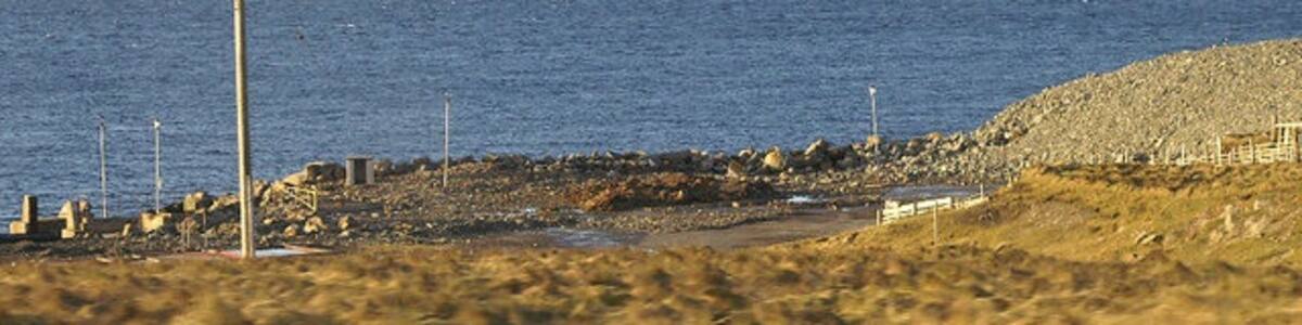 Photo "Former ferry terminal at Oddsta, Fetlar Almost all the buildings and fittings have been removed, but the concrete jetty where the ro-ro ramp was installed is just visible on the extreme left." by Mike Pennington (Creative Commons Attribution-Share Alike 2.0) / Cropped from original