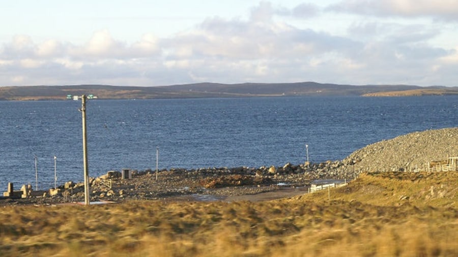 Photo "Former ferry terminal at Oddsta, Fetlar Almost all the buildings and fittings have been removed, but the concrete jetty where the ro-ro ramp was installed is just visible on the extreme left." by Mike Pennington (Creative Commons Attribution-Share Alike 2.0) / Cropped from original