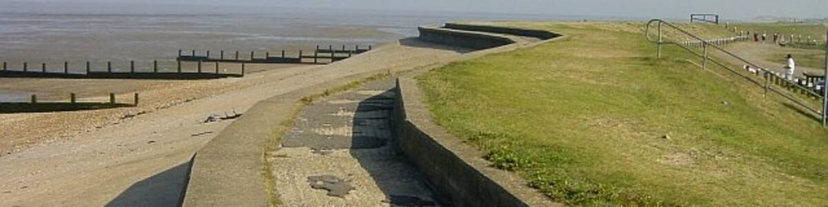Photo "Sea Wall near the Café, Shellness Beach. Part of Leysdown Country and Coastal Park." by Penny Mayes (Creative Commons Attribution-Share Alike 2.0) / Cropped from original