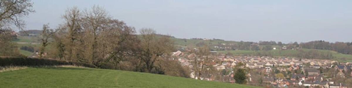 Photo "Below Benthouse Farm, looking to Upper Tean Rolling farmland surrounds the village of Upper Tean, where a large textile mill provided the main employment." by Alan Murray-Rust (Creative Commons Attribution-Share Alike 2.0) / Cropped from original