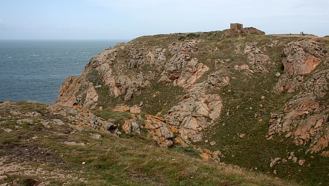 Gros Nez Castle natural defences. Thought to have been built by Sir John des Roches in about 1330. It used the natural defences of the steep cliffs for three sides and a ditch with along the landward side where the locally quarried granite walls were thickest.