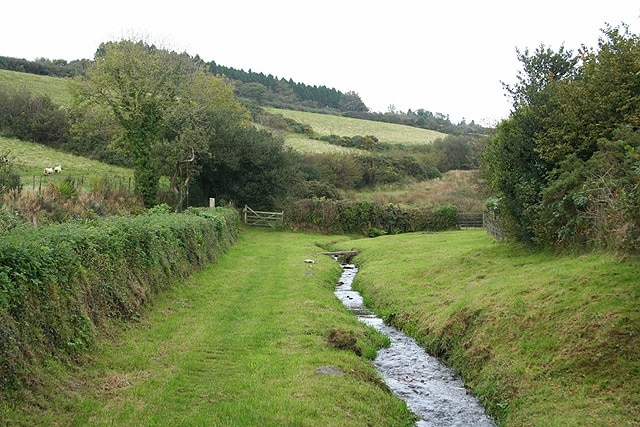 Sourton: River Lew at Forda Little more than half a mile from its source on Sourton Down. The putative course of the Roman Road from Exeter and North Tawton to the Tamar is thought to have run just over the hedge on the left. See also P Weddell and S Reed, Excavations at Sourton Down, Okehampton 1986-1991: Roman road, deserted hamlet and other landscape features, Proceedings of the Devon Archaeological Society 55, 1997, 134-5