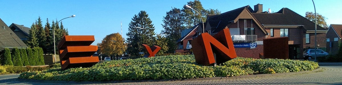 Photo "Kunst im Kreisverkehr Kiesbergstr. Ecke Frerener Str. Ecke Josefstraße, Lingen-Laxten. Die 1.60 m hohen, stählernen Buchstaben, L-A-X-T-E-N, lassen sich nur lesen, wenn man einmal ganz im Kreis herum fährt. Die Idee für die Gestaltung des ältesten Kreisverkehrs in Lingen entstand 2012 in Zusammenarbeit zwischen Ortsrat und Verwaltung. 2015 wurde das Kunstwerk realisiert." by Welt-der-Form (Creative Commons Attribution-Share Alike 4.0) / Cropped from original