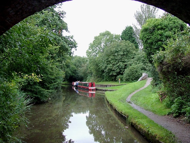 Stratford-upon-Avon Canal at Hockley Heath, Solihull. The canal is seen here from below the arch of Bridge No 25, which carries the A4300 Stratford Road from Solihull. Ahead to the right is a short canal arm which used to lead to a coal wharf. 1716384 The Stratford-upon-Avon Canal was built from King's Norton Junction (with the Worcester and Birmingham Canal) to Kingswood Junction (with the Warwick and Birmingham Canal - now Grand Union Canal) by 1803. A second phase of construction started in 1812, and by 1815 was connected to the River Avon in Stratford. Total length 25.5 miles, with 54 locks.