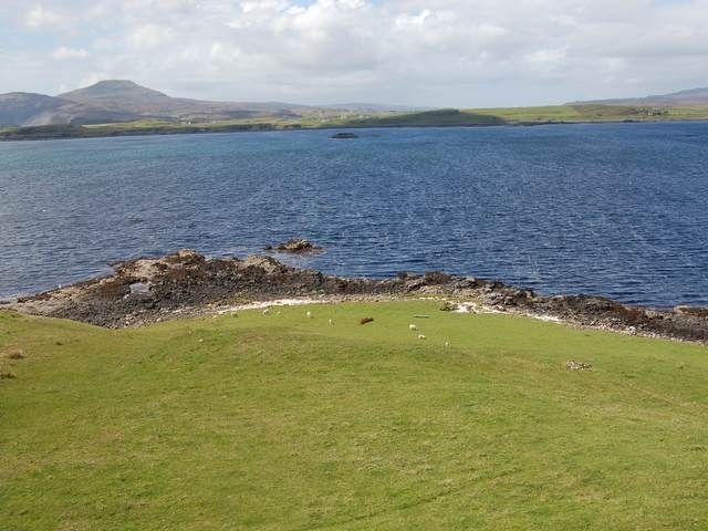 Grazings at Eabost West. Croft land with sheep grazing. The view is across Loch Bracadale to the mouth of Loch Caroy.