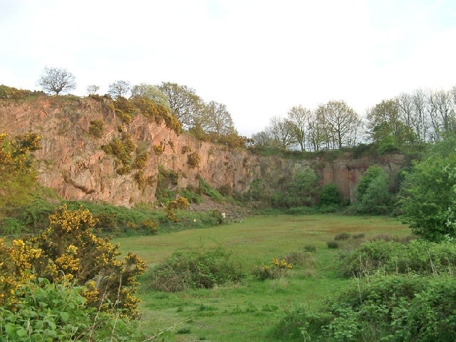 Morley Quarry, Shepshed, looking south. Charnwood Borough Council acquired this site, ostensibly to equip for climbing. Although it isn't actually much good for climbing, it does show the outline of a wadi (desert stream) bed infilled with Triassic-Rhaetic marls at the top of the southern face. The eastern face, seen here, reveals northward sloping Charnwood volcanics of Precambrian age. The quarry would have been built to excavate one of the many syenite intrusions in Charnwood Forest.