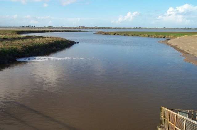 The Huntspill River where it enters the Parrett Estuary Taken from the sluice gate, with the estuary of the River Parrett in the middle distance.