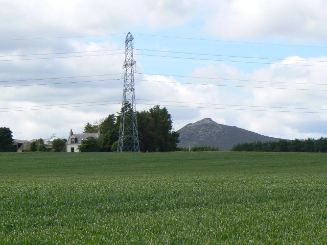 Pylon by the farm West Balquhain Farm with Mither Tap on Bennachie in the background.