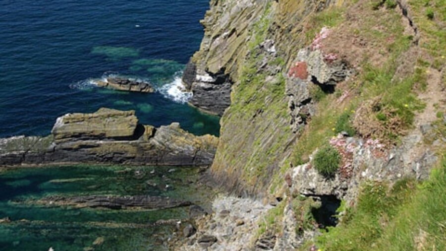 Photo "Peel to Glenmaye coastal path at Ellan ny Maughol. Isle of Man. The footpath runs from Peel hill to Glen Maye, a distance of about 4 kms. and for most of this distance it follows the cliff edge." by Andy Radcliffe (Creative Commons Attribution-Share Alike 2.0) / Cropped from original