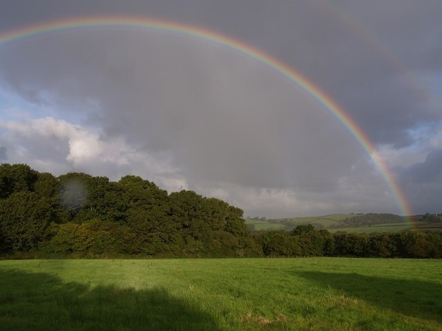 Double rainbow near Iddesleigh. Taken at the same time as 569318, this view looks across to an unnamed wood east of Fursdon Cottage. Rain on the lens suggests the weather conditions.