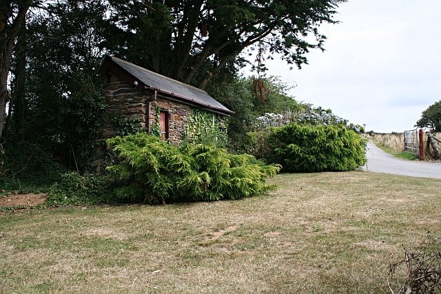 Entrance to a Holiday Park. The building to the left is a curious small-scale mock-up of an old building. Only the front half exists, there is no back to it at all.