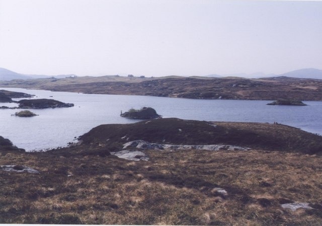 Loch Barabhat and Dun. The dun in loch Barabhat with the crofts of Tacleit beyond. Featuring a fisherman and some rough moorland.