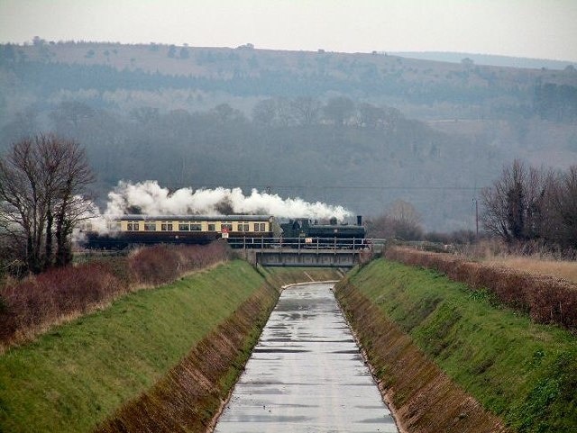 River Avill Overflow Bridge. A West Somerset Railway steam train passes over the bridge that spans the River Avill Overflow Channel near Dunster.