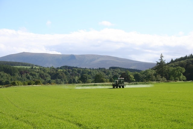 Spraying at Craigellachie Farming work on a Speyside field at Craigellachie with Benrinnes in the background.