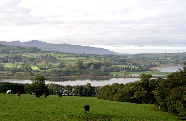 Llangors Lake - south end As viewed from Cathedine. The church at Llangasty Talyllyn is to the right and the peaks of Pen y Fan and Corn Du are clearly visible to the right