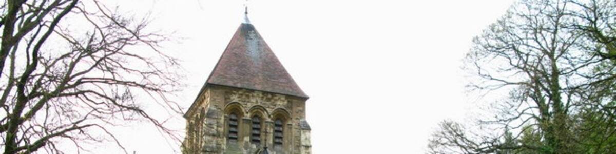 Photo "St John's Church The building was erected in 1874, but looks much older. A doorway into the hillside in the graveyard adds "character" to the Church." by David Rogers (Creative Commons Attribution-Share Alike 2.0) / Cropped from original