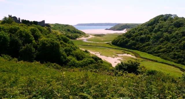 Pennard Pill Looking down the Pennard Valley to the sea, the ruined Pennard Castle is visible at the top of the cliff on the left.