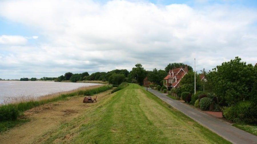 Photo "Flood Bank, Saltmarshe, East Riding of Yorkshire, England. The tiny village of Saltmarshe is situated on the north bank of the Ouse, but villagers must either climb the high flood bank or look out of first floor windows to see the river, which at high tide is above the level of the road." by Gordon Hatton (Creative Commons Attribution-Share Alike 2.0) / Cropped from original