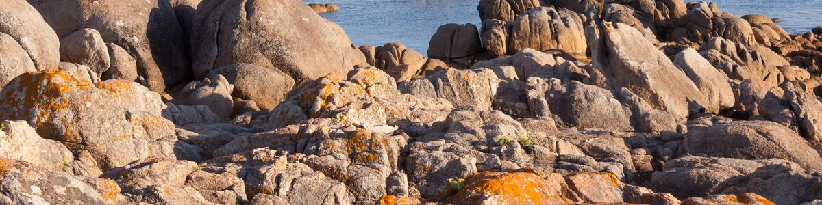 Photo "Sea and rocks in the ria of Pontevedra. Ons island at background. San Vicente do Mar, O Grove, Galicia, Spain." by Lmbuga (Creative Commons Attribution-Share Alike 3.0) / Cropped from original