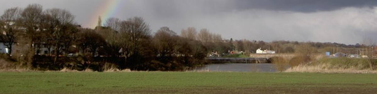 Photo "Rainbow over Ribble Rain coming in from the East late on a sunny March afternoon in Preston produced this one bright end of a rainbow." by Patrick (Creative Commons Attribution-Share Alike 2.0) / Cropped from original