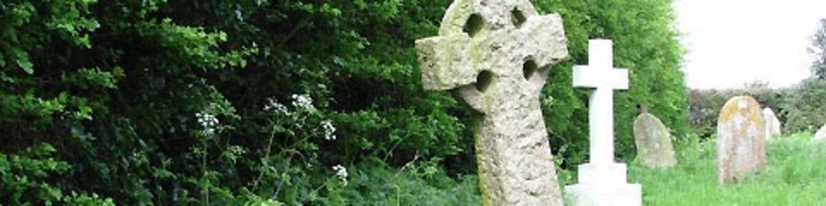 Photo "St Mary's church - churchyard A little stone angel standing guard above a child's grave. The churchyard serves as a conservation area: the grass between the headstones is not kept short by regular cutting and wild flowers are allowed to grow; at this time of the year these are mainly daffodils (past their best) and bluebells." by Evelyn Simak (Creative Commons Attribution-Share Alike 2.0) / Cropped from original