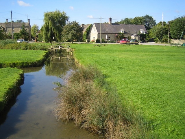 Bledington: The Kings Head Inn Viewed across The Green from the bridge over the brook on Stow Road, the website of The Kings Head Inn is here http://www.thekingsheadinn.net/ The establishment is a true inn in the sense of offering accommodation, a restaurant and a bar. Curiously the website describes Bledington as being in Oxfordshire, but the Ordnance Survey mapping and road signs have it in Gloucestershire...