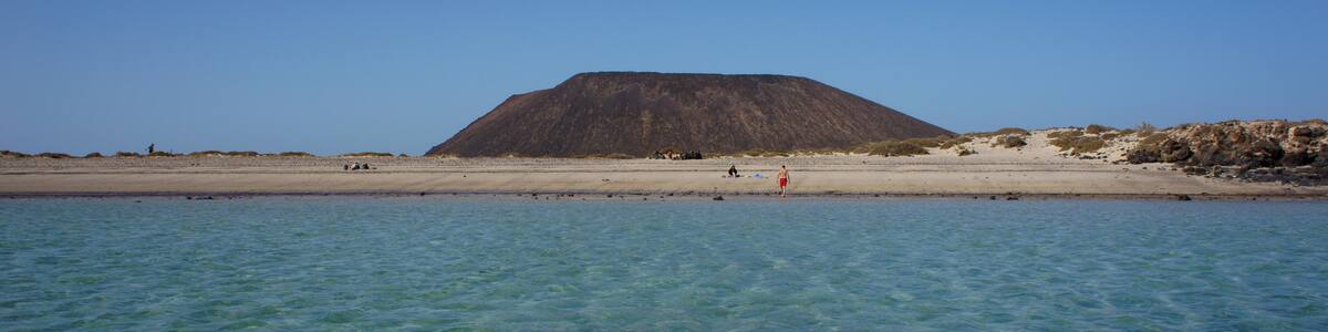Photo "Playa de la Calera (Playa La Concha) on the island of Lobos" by Jarek Prokop (Creative Commons Attribution 3.0) / Cropped from original