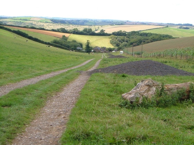 Woolcombe Farm. The only buildings in this square, taken from outside, looking down the track leading from the A381 to the farm. The valley in which the farm sits swings right beyond it past Woolcombe Wood to join the Torr Brook.