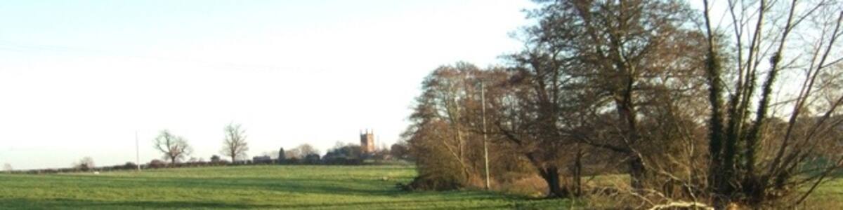 Photo "Gamesley Brook Looking down the brook course towards Seighford village and church." by Simon Huguet (Creative Commons Attribution-Share Alike 2.0) / Cropped from original