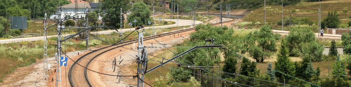 Photo "Train tracks in Villamanín de la Tercia, León, Spain." by Lmbuga (Creative Commons Attribution-Share Alike 3.0) / Cropped from original